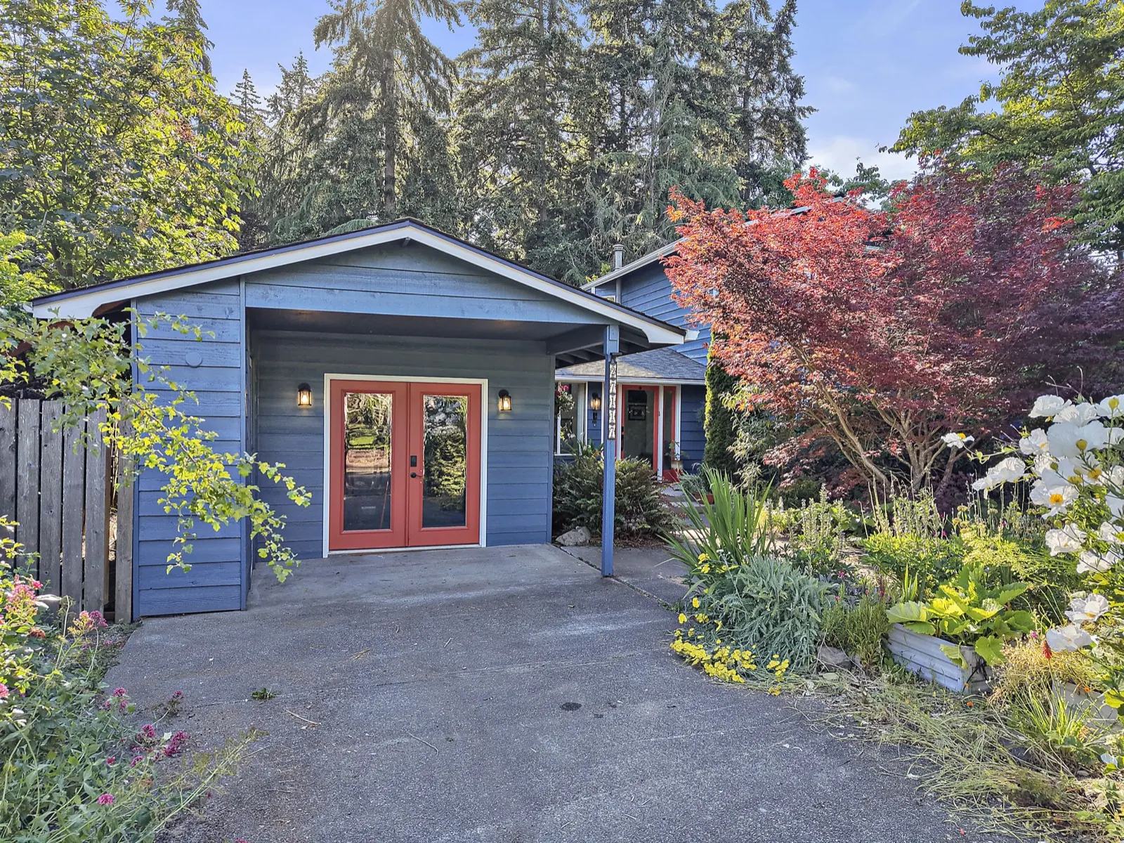Blue Kent home surrounded by mature garden plantings